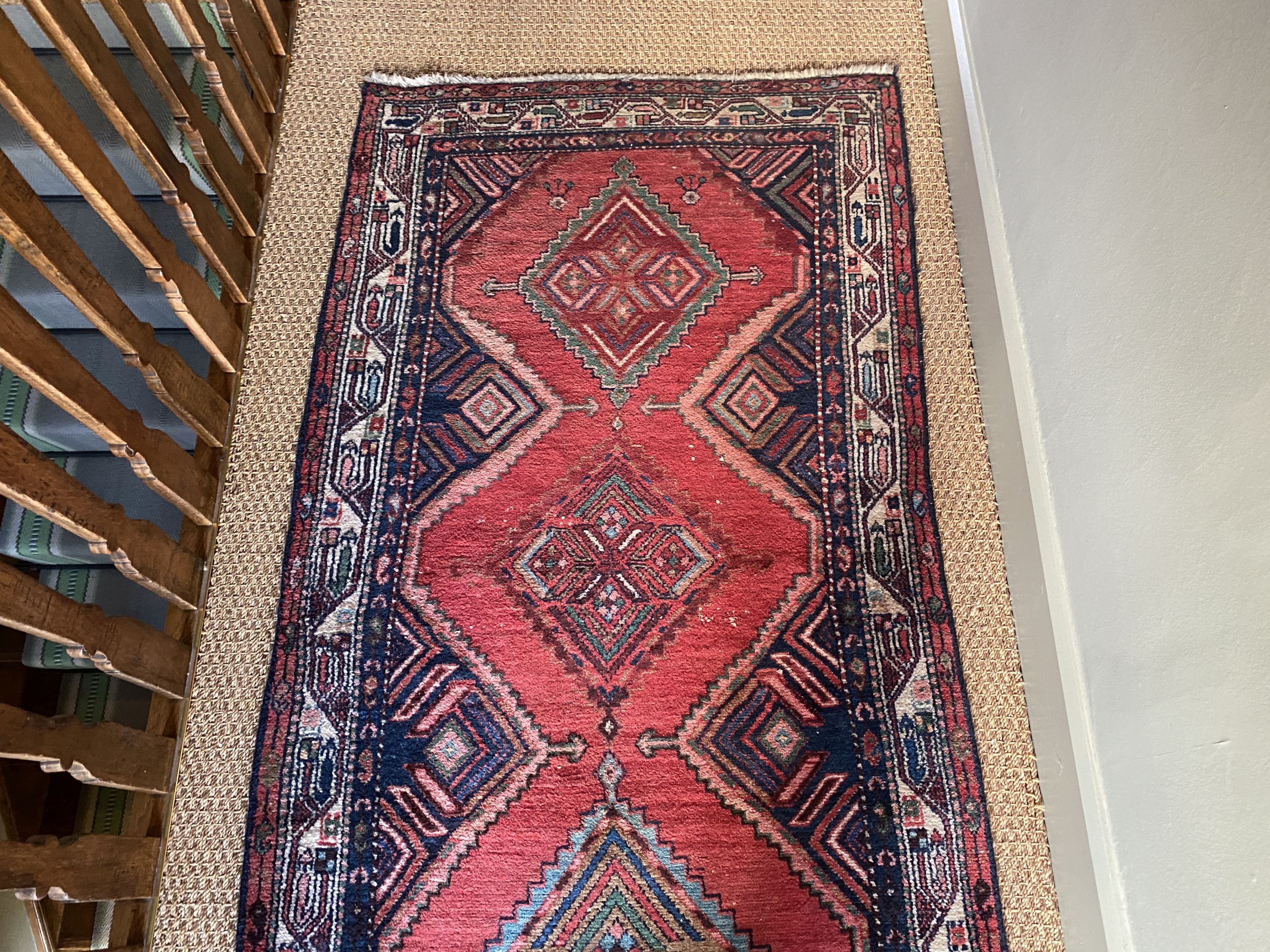 A Persian red ground runner, with five central lozenges, multi-bordered, 303 x 98cm